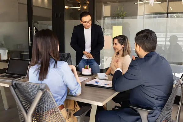 Uśmiechnięta kobieta pracująca przy laptopie w kawiarni